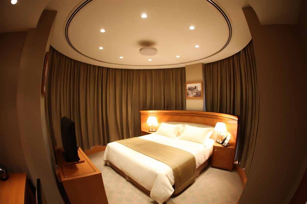Wiseman Grand Hotel Doha Bagian luar foto A bedroom in a hotel